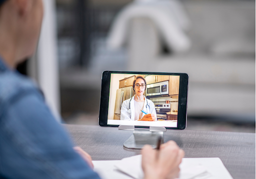 Respiratory disease patient listening to the doctor during a video call and taking notes.