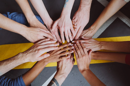 Multiple hands placed together in a circle, symbolizing unity and support in COPD support groups.