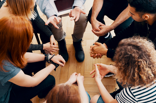 A group of people sitting in a circle engaging in a discussion, symbolizing psychological support and group therapy in COPD care.