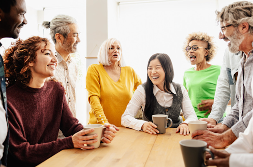 A diverse group of people sharing a laugh around a table, signifying social interaction in COPD support.