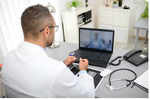 Doctor conducting an online consultation with elderly female COPD patient via video call.