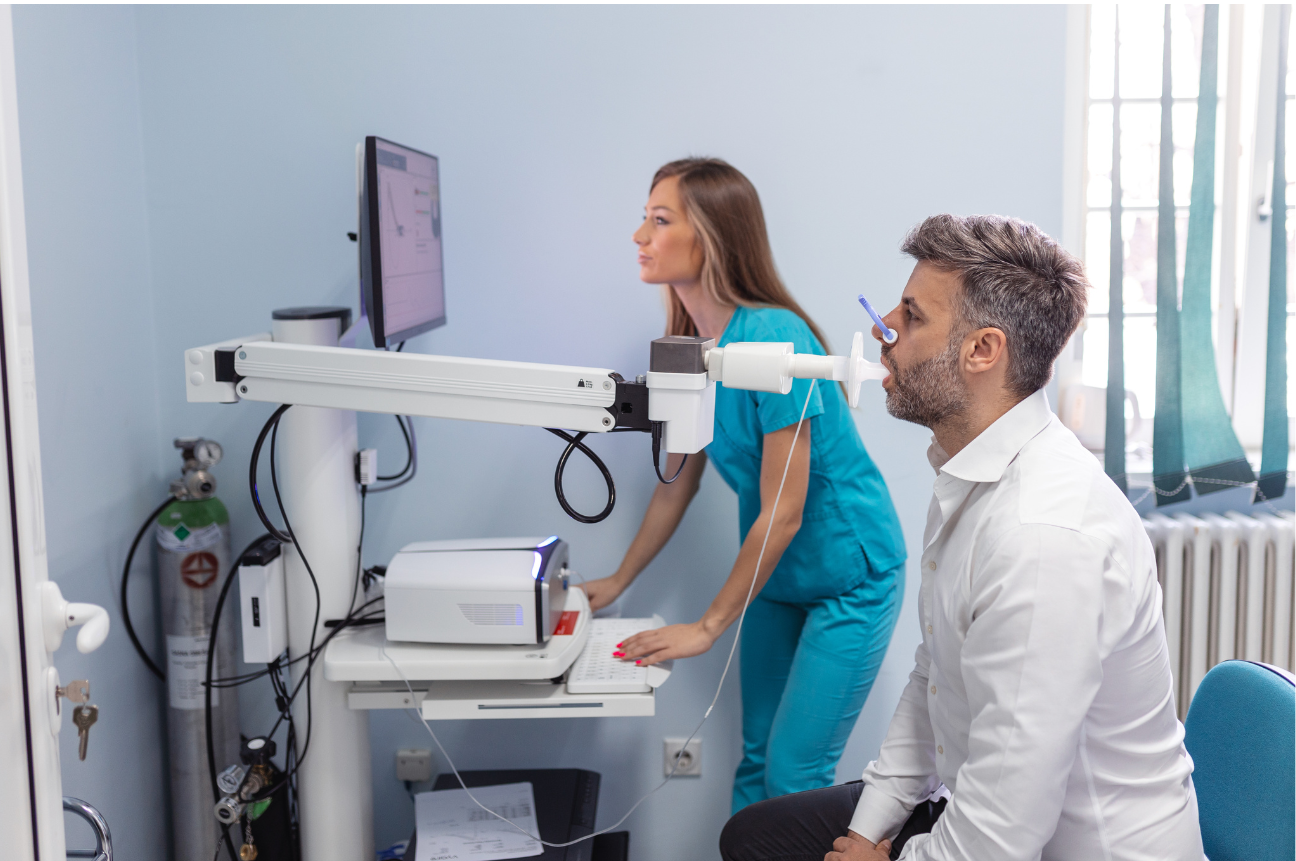 Man undergoing a spirometry test supervised by a healthcare professional to assess lung function.