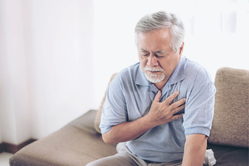 Elderly man clutching his chest, possibly experiencing chest discomfort related to COPD.
