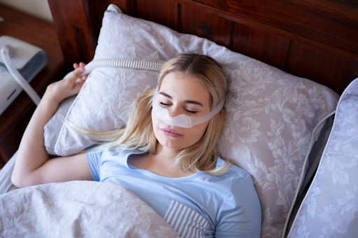Woman sleeping with a CPAP mask for sleep apnea management.