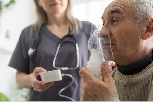 An elderly man wearing an oxygen mask, assisted by a healthcare provider, symbolizing support in respiratory therapy.