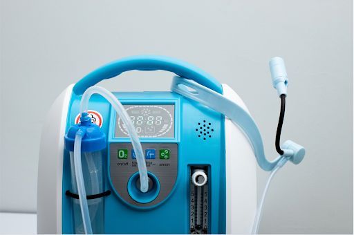 Close-up of a nebulizer device for respiratory therapy, showing the tube and controls for medication administration.