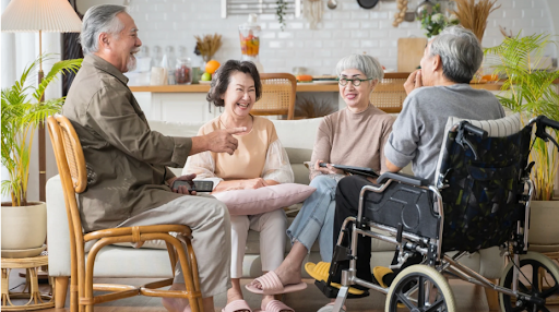 A group of friends and family conversing with a COPD patient in a wheelchair, emphasizing informal caregiving roles
