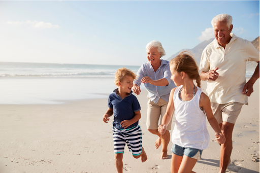 Grandparents with their grandchildren, running on a beach, showing the importance of family in COPD patients' quality of life.