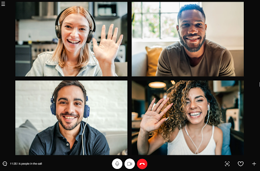 A virtual meeting with four participants smiling and waving, representing an online self-help group connecting for support.